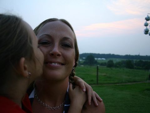 A girl kisses a smiling woman on the cheek