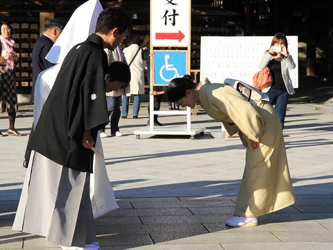 A man and a woman in traditional Japanese clothes bow to each other in Tokyo