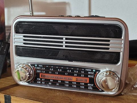 A small silver radio on a wooden table