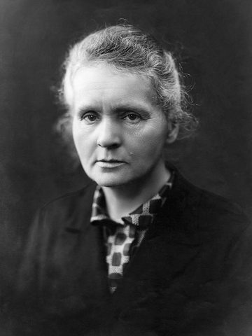 Marie Curie with gray hair and a dark jacket, in a black-and-white photo