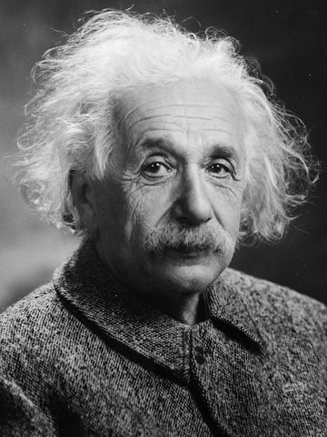 Albert Einstein with white hair and a mustache, in a black-and-white photo