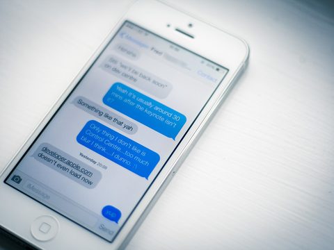 A cell phone showing a text message conversation in blue and gray bubbles
