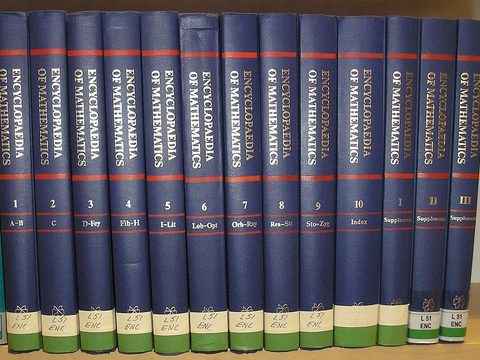 A row of blue encyclopedia books on a shelf