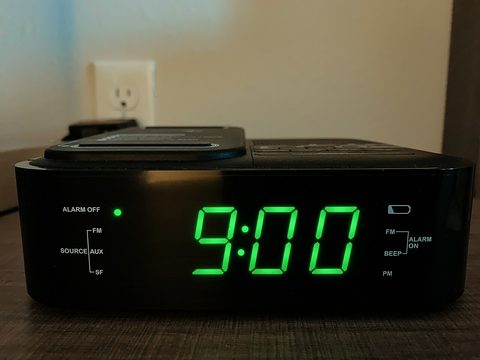 A black alarm clock showing 9:00